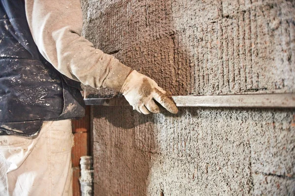 Vrai ouvrier de la construction faisant un mur à l'intérieur de la nouvelle maison . — Photo