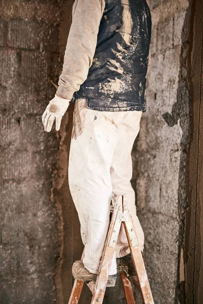 Gerçek inşaat işçisi yeni evin içinde bir duvar yapma.