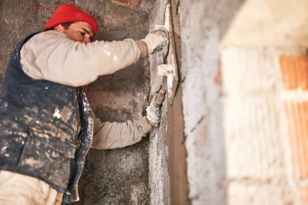 Vrai ouvrier de la construction faisant un mur à l'intérieur de la nouvelle maison . — Photo