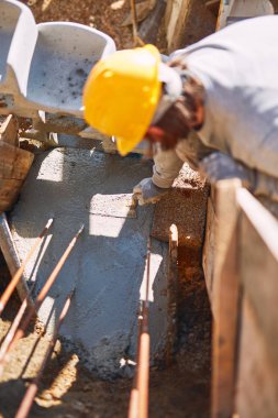 Ağır bir sitede inşaat işçisi sıkı çalışma yapıyor.