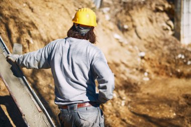 Ağır bir sitede inşaat işçisi sıkı çalışma yapıyor.