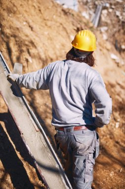 Ağır bir sitede inşaat işçisi sıkı çalışma yapıyor.