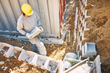 Ağır bir sitede inşaat işçisi sıkı çalışma yapıyor.