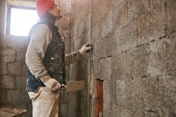 Vrai ouvrier de la construction faisant un mur à l'intérieur de la nouvelle maison . — Photo