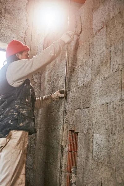 Vrai ouvrier de la construction faisant un mur à l'intérieur de la nouvelle maison . — Photo