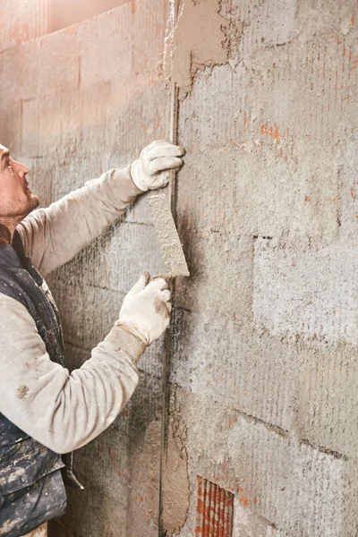 Vrai ouvrier de la construction faisant un mur à l'intérieur de la nouvelle maison . — Photo