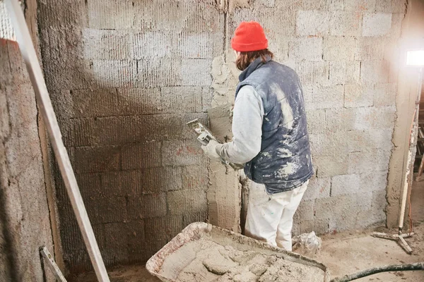 Vrai ouvrier de la construction faisant un mur à l'intérieur de la nouvelle maison . — Photo