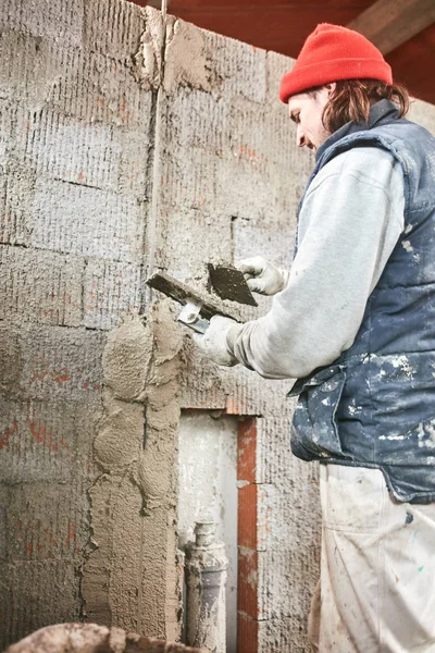 Vrai ouvrier de la construction faisant un mur à l'intérieur de la nouvelle maison . — Photo