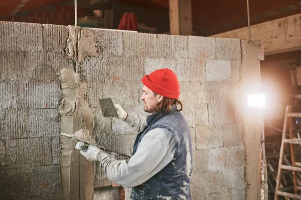 Vrai ouvrier de la construction faisant un mur à l'intérieur de la nouvelle maison . — Photo