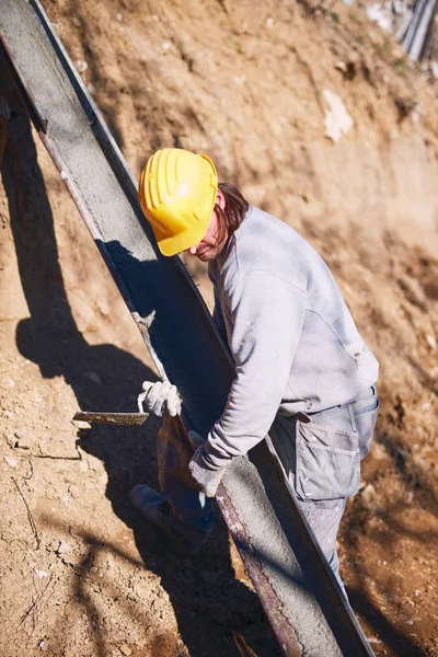 Ağır bir sitede inşaat işçisi sıkı çalışma yapıyor.