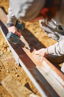 Ağır bir sitede inşaat işçisi sıkı çalışma yapıyor.