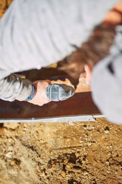 Ağır bir sitede inşaat işçisi sıkı çalışma yapıyor.