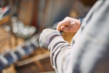 Ağır bir sitede inşaat işçisi sıkı çalışma yapıyor.