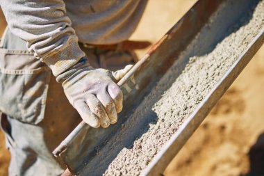 Ağır bir sitede inşaat işçisi sıkı çalışma yapıyor.