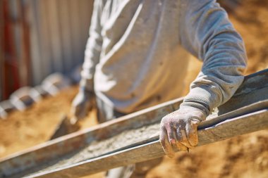 Ağır bir sitede inşaat işçisi sıkı çalışma yapıyor.