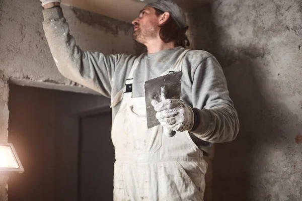 Worksman plastering gypsum walls inside the house.