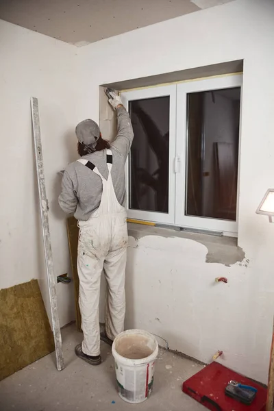 Рабочий оштукатурировал гипсовые стены внутри дома . — стоковое фото