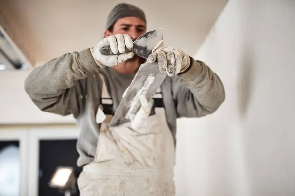 Worksman plastering gypsum walls inside the house.