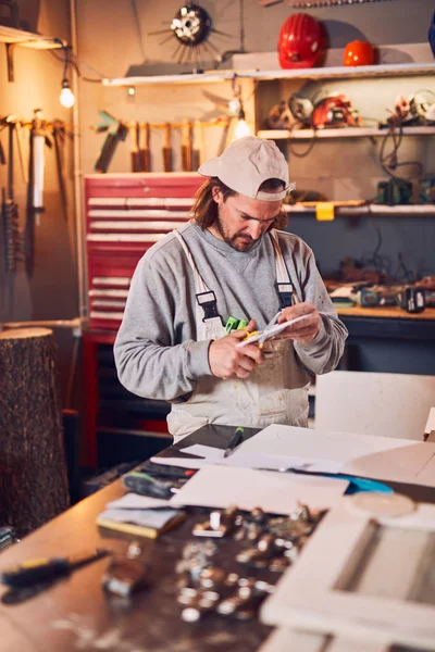 Carpintero macho fijando madera vieja en un taller retro vintage . — Foto de Stock