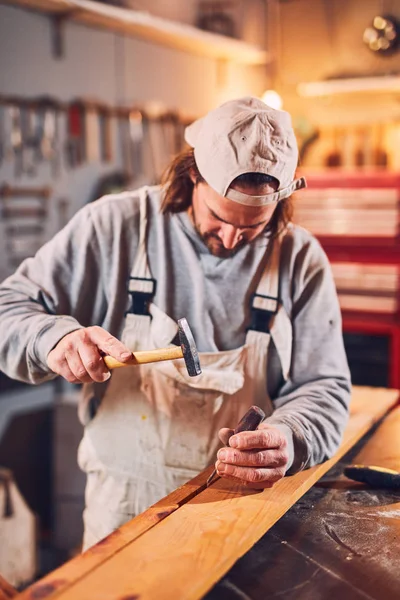Carpintero macho fijando madera vieja en un taller retro vintage . — Foto de Stock