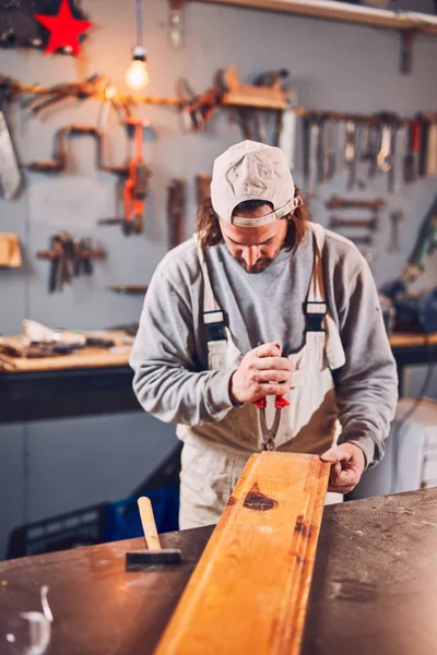 Male carpenter fixing old wood in a retro vintage workshop. — Stock Photo, Image