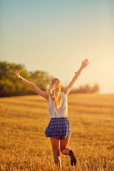 Giovane donna che salta e corre in un campo di grano . — Foto Stock