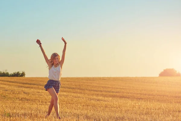 Giovane donna che salta e corre in un campo di grano . — Foto Stock