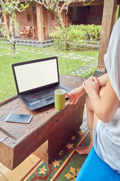 Fille en utilisant un ordinateur portable sur une véranda / terrasse à la maison . — Photo