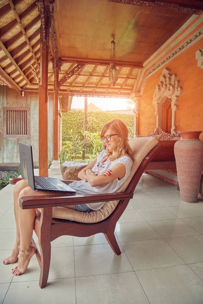 Chica usando el ordenador portátil en un porche / terraza en casa . — Foto de Stock