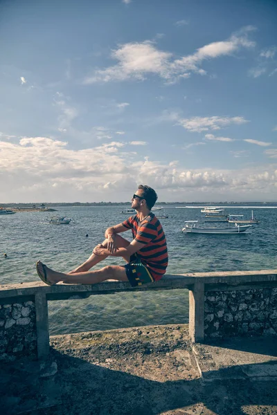 Tropik bir adada okyanus koyunda oturan adam. — Stok fotoğraf