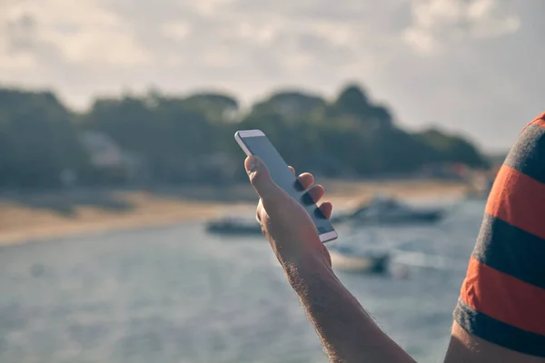 Hombre usando celular en la playa del océano . —  Fotos de Stock