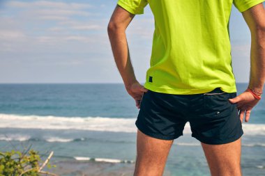 Okyanusa yakın tropik egzotik bir kayalıkta sporcu.