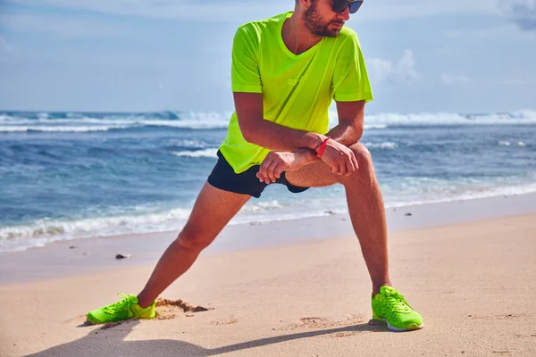 Deportista estirándose en una playa de arena tropical . —  Fotos de Stock