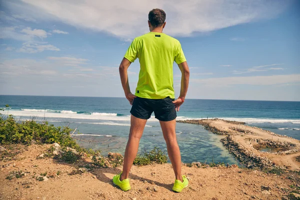 Sportman op een tropische exotische klif in de buurt van de Oceaan. — Stockfoto