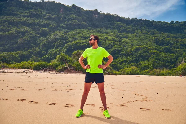 Deportista estirándose en una playa de arena tropical . —  Fotos de Stock