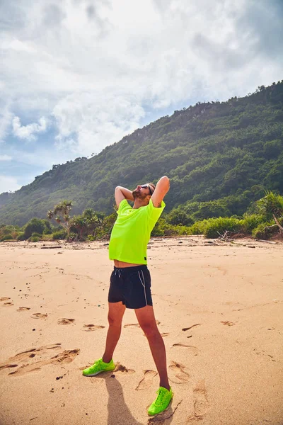 Deportista estirándose en una playa de arena tropical . — Foto de Stock