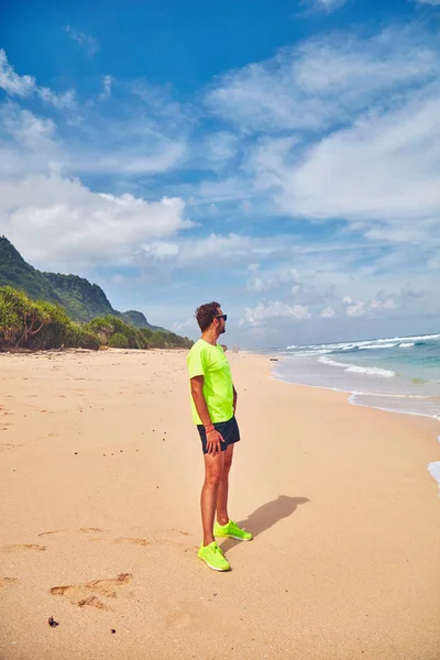 Deportista estirándose en una playa de arena tropical . — Foto de Stock