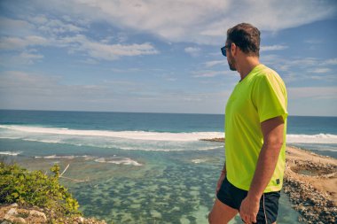 Okyanus yakınında tropikal egzotik uçurumun üzerinde uzanan Sportsman.