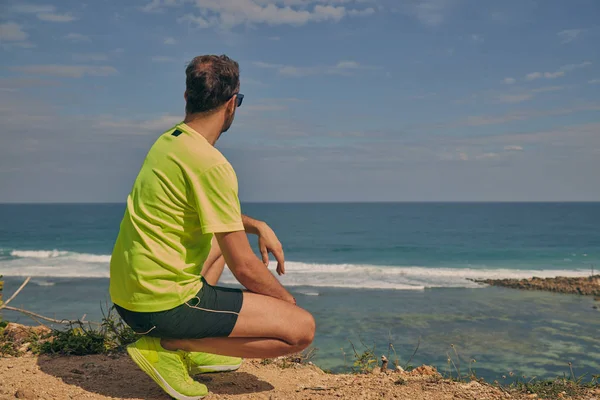 Okyanus yakınında tropikal egzotik uçurumun üzerinde uzanan Sportsman.