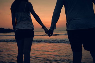 Günbatımı bir kız silüeti / gündoğumu zaman okyanusun içinde.