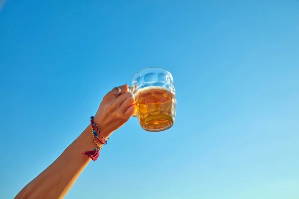 Жінка тримає келих пива на відкритому повітрі / зовні . — стокове фото