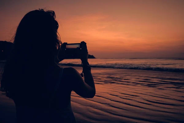 Mujer usando celular en una playa tropical del océano . — Foto de Stock