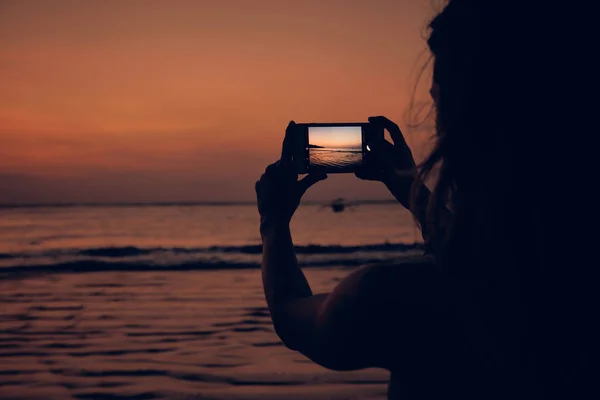 Mujer usando celular en una playa tropical del océano . — Foto de Stock