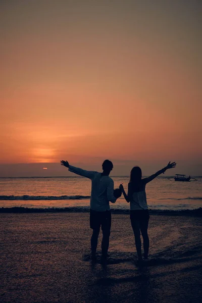 Silhueta de uma menina no pôr do sol / nascer do sol tempo sobre o oceano . — Fotografia de Stock