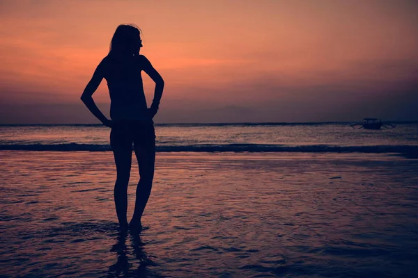 Günbatımı bir kız silüeti / gündoğumu zaman okyanusun içinde. — Stok fotoğraf