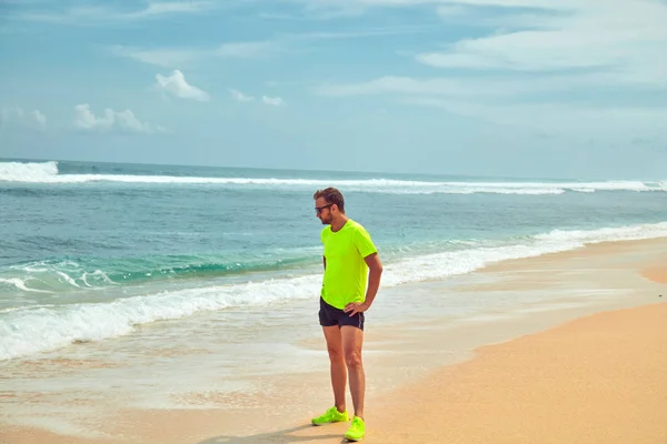 Sportivo che si estende su una spiaggia di sabbia tropicale . — Foto Stock