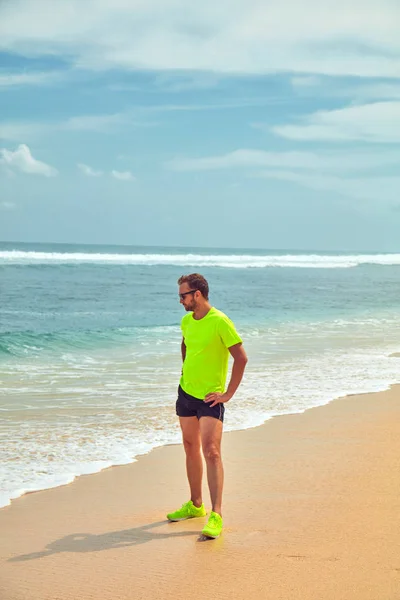 Deportista estirándose en una playa de arena tropical . — Foto de Stock