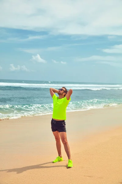 Deportista estirándose en una playa de arena tropical . —  Fotos de Stock