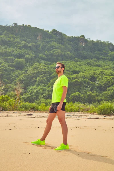 Deportista estirándose en una playa de arena tropical . — Foto de Stock