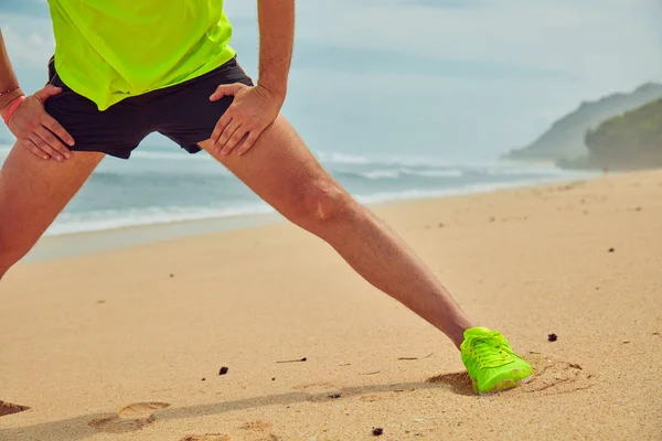 Deportista estirándose en una playa de arena tropical . — Foto de Stock